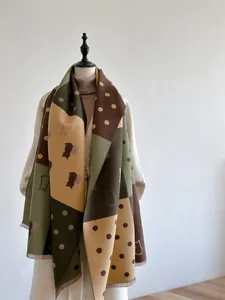 Detail of color-block cashmere scarf featuring geometric patterns and cat silhouettes