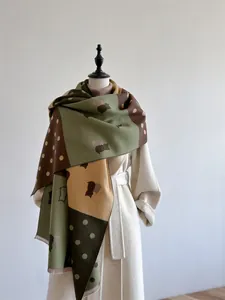 Detailed close-up of color-block cashmere shawl with polka dots and animal patterns