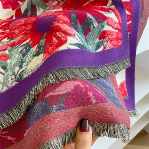 Close-up of ethnic style shawl featuring red floral jacquard and grey fringe trim
