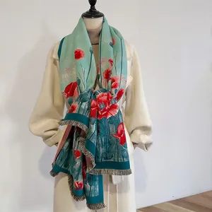 Detailed view of teal floral shawl with red poppy print and elegant fringe tassels