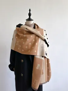 Detail of color-block cashmere scarf featuring polka dots and cat silhouettes with frayed edges