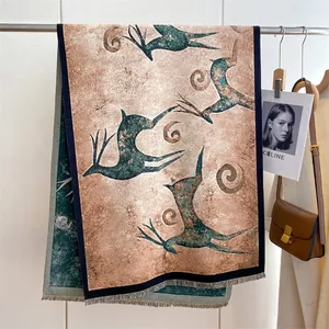 Detailed view of ethnic wool shawl with vintage deer patterns and delicate tassels