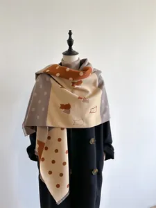 Close-up of cashmere scarf showing cat silhouettes, polka dots, and fine fringe edges