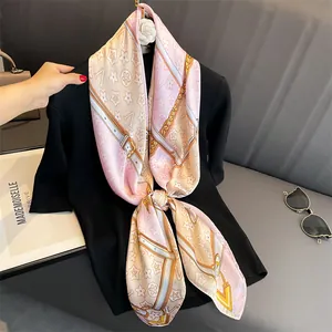 Detailed close-up of fashion print silk scarf with floral motifs and luxury chain patterns