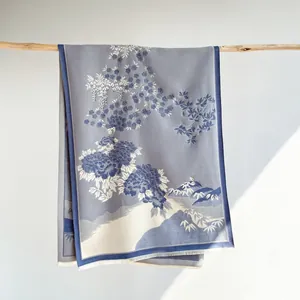 Detail of grey-blue cashmere scarf with vintage floral pattern and elegant fringe edges