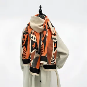 Close-up of winter scarf detail with poker symbols, geometric patterns and short tassels