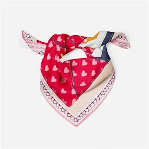 Detail of red and pink silk scarf showing heart patterns and geometric borders