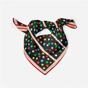 Detail of black silk scarf featuring colorful dots and leather strap rivet prints