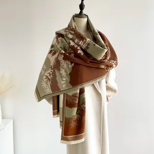 Detail of vintage floral pattern on warm cashmere-like shawl with tassel edges