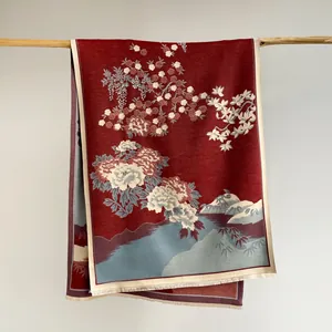 Detail of red Chinese style scarf with floral jacquard pattern and fringe trim
