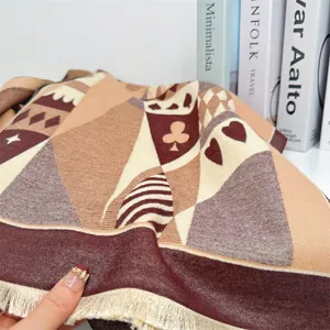 Close-up of thick knitted scarf with poker patterns and fringe edges on books