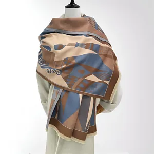 Close-up detail of a thick cashmere-feel scarf with geometric patterns and fringe