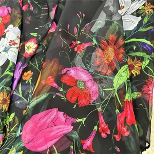 Détail du tissu en mousseline noire avec imprimé floral coloré et texture translucide