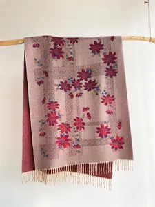 Detailed macro view of vintage floral jacquard knit scarf with elegant fringe tassels