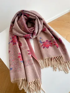 Detailed view of pink floral scarf with red blossoms and long fringe tassels