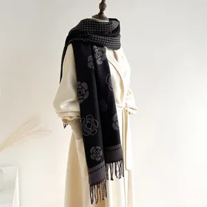 Macro detail of houndstooth and camellia patterns on soft fringed cashmere scarf
