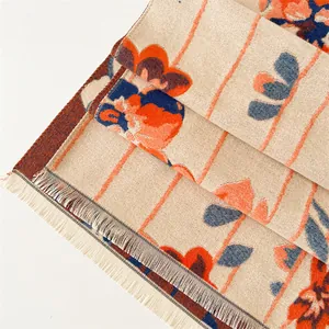 Detailed view of floral jacquard knit shawl with fringe and vintage stripe pattern
