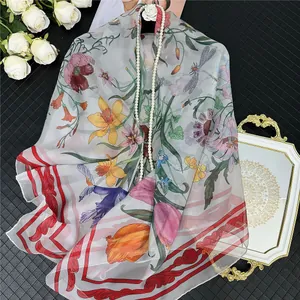 Elegante foulard in seta grigia con stampe floreali vivaci e insetti su fondo nero