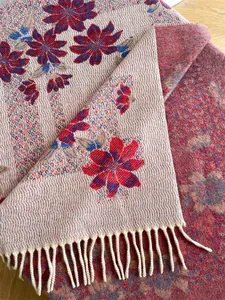 Close-up of floral jacquard cashmere scarf featuring double-sided knit and beige fringes