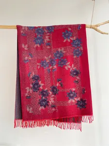 Detail of red floral scarf with soft cashmere texture and elegant fringe tassels