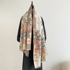 Close-up of vintage floral cashmere shawl with orange flower print and tassel edges