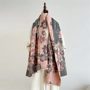 Close-up of pink and grey cashmere shawl with floral patterns and delicate fringe details