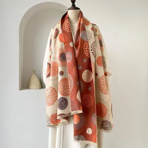 Close-up of bohemian cashmere shawl with geometric dot patterns and orange tassels