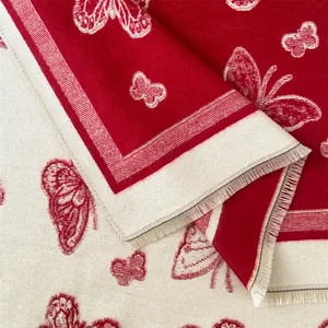 Detailed close-up of thick winter scarf with red butterfly pattern and soft fringe