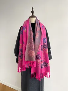 Detailed close-up of pink floral cashmere scarf with fringed edges on model stand