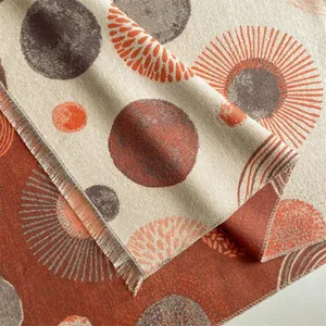 Detail of bohemian cashmere-like scarf with abstract sun patterns and fringed edges
