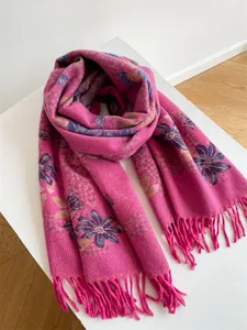 Close-up of floral jacquard pattern and handmade tassels on fuchsia cashmere-like scarf