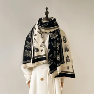 Detailed close-up of butterfly jacquard pattern and soft fringe on cashmere winter scarf