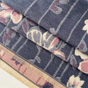 Detail of premium cashmere scarf with jacquard floral patterns and yellow tassels