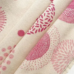 Close-up of Bohemian cashmere-like scarf with pink geometric patterns and soft fringes