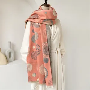 Detail view of pink and grey bohemian cashmere-like shawl with geometric patterns and tassels
