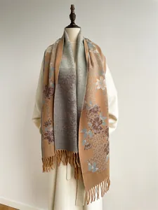 Detail of floral cashmere-like scarf with caramel base and elegant long tassels