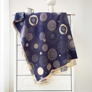 Detailed texture of bohemian cashmere-feel scarf in navy blue with white geometric patterns