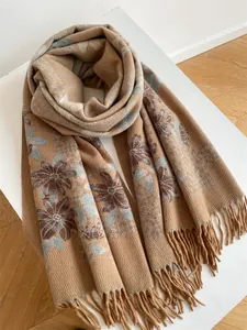 Detail of floral jacquard pattern and long tassels on soft cashmere-like autumn scarf