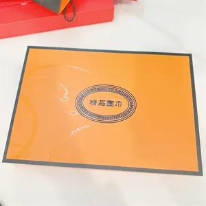 Detalle macro de caja de regalo naranja para bufanda con patrones de cadena y bordes negros