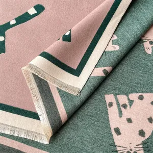 Detail van dubbelzijdige sjaal met roze en groene kattenjacquard en franje kwastjes