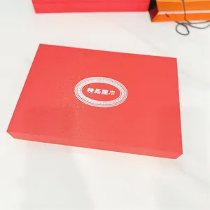 Detalle de la caja de regalo roja rectangular grande con etiqueta de bufanda premium