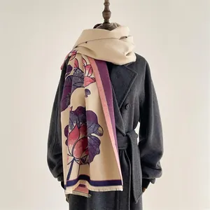 Detail of floral lotus scarf with soft fringe edge on a charcoal grey coat texture