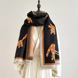 Detailopname van een sjaal met schattige oranje kattenpatronen en korte franjes