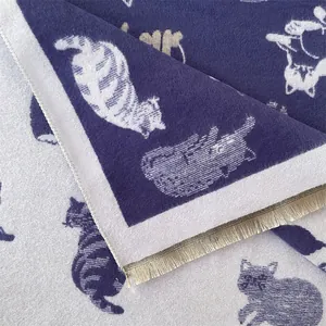 Detail van dubbelzijdige jacquard sjaal met kattenpatroon en fijne korte franjes