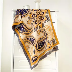 Détail d'un châle pashmina à motif paisley jaune et bleu avec des franges fines