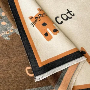 Detailopname van winterse kasjmierachtige sjaal met kattenpatroon en witte franjes