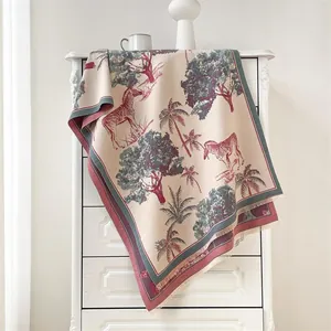 Detailed view of soft zebra and palm tree jacquard knit scarf with elegant fringe edges