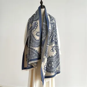 Détail de châle pashmina à motif paisley bleu marine et beige avec bordures à franges
