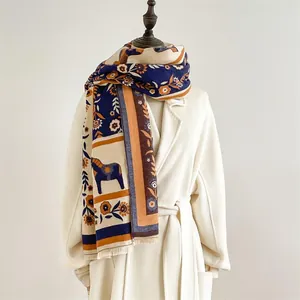 Détail d'une écharpe d'hiver avec motif poney rétro et franges sur un manteau blanc