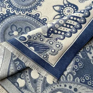 Détail de motif cachemire sur une écharpe épaisse avec des franges grises